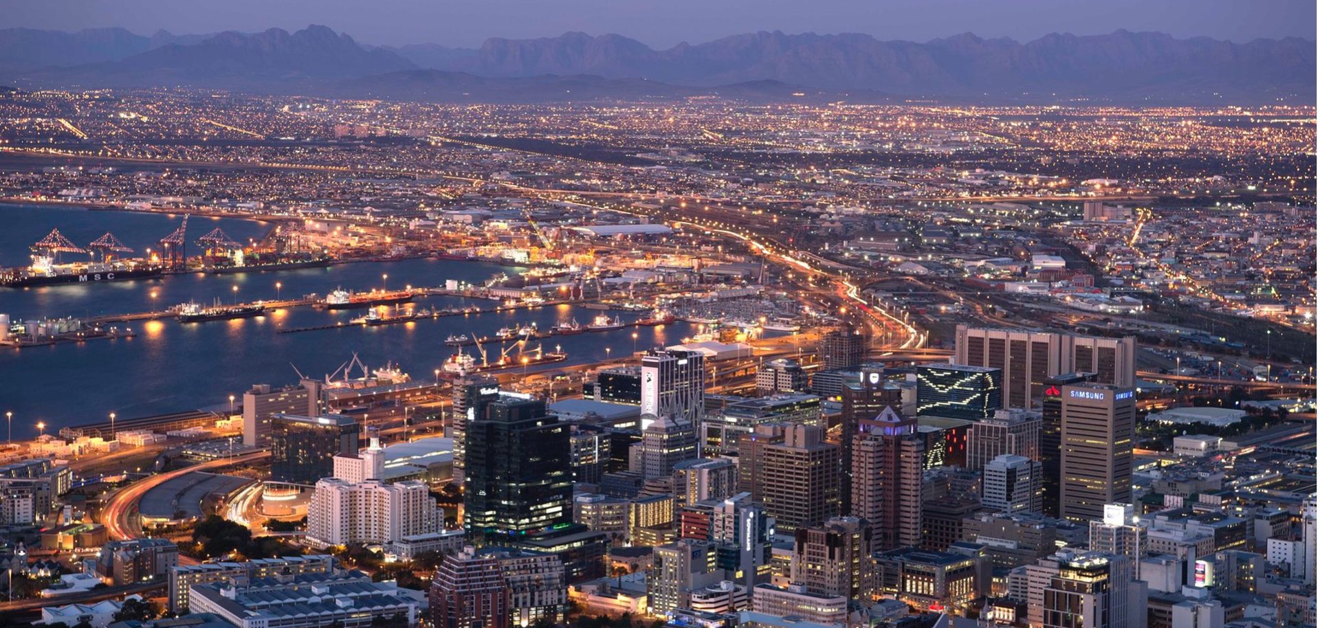 Cape Town city skyline and harbour at dusk, with Table Mountain in the background